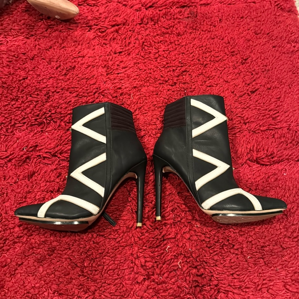 Black and white leather booties with high heel and pointed toe